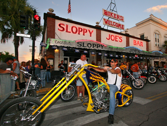 In this photo released by the Florida Keys News Bureau, a motorcycle enthusiast parks his bike in front of Sloppy Joe's Bar in Key West, Fla., during the 35th Annual Key West Poker Run Friday, Sept. 14, 2007. Riders on as many as 10,000 bikes have traversed down the Florida Keys Overseas Highway, drawing cards at designated stops. The weekend event, that ends Sunday, serves as a charity fundraiser for the Diabetes Research Institute and educational scholarships for Keys students. (AP Photo/Florida Keys News Bureau, Rob O'Neal)