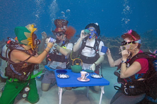 Divers including from left, Katie Jennele, Bob Rowland, Eric Rolfe and Alicia Merel act out an "Alice in Wonderland" underwater tea party at the Underwater Music Festival in the Florida Keys National Marine Sanctuary Saturday, July 10, 2010, near Big Pine Key, Fla. The annual subsea concert attracted more than 500 divers and snorkelers to listen to a local radio station's broadcast piped beneath the sea with underwater speakers. (Bob Care/Florida Keys News Bureau)
